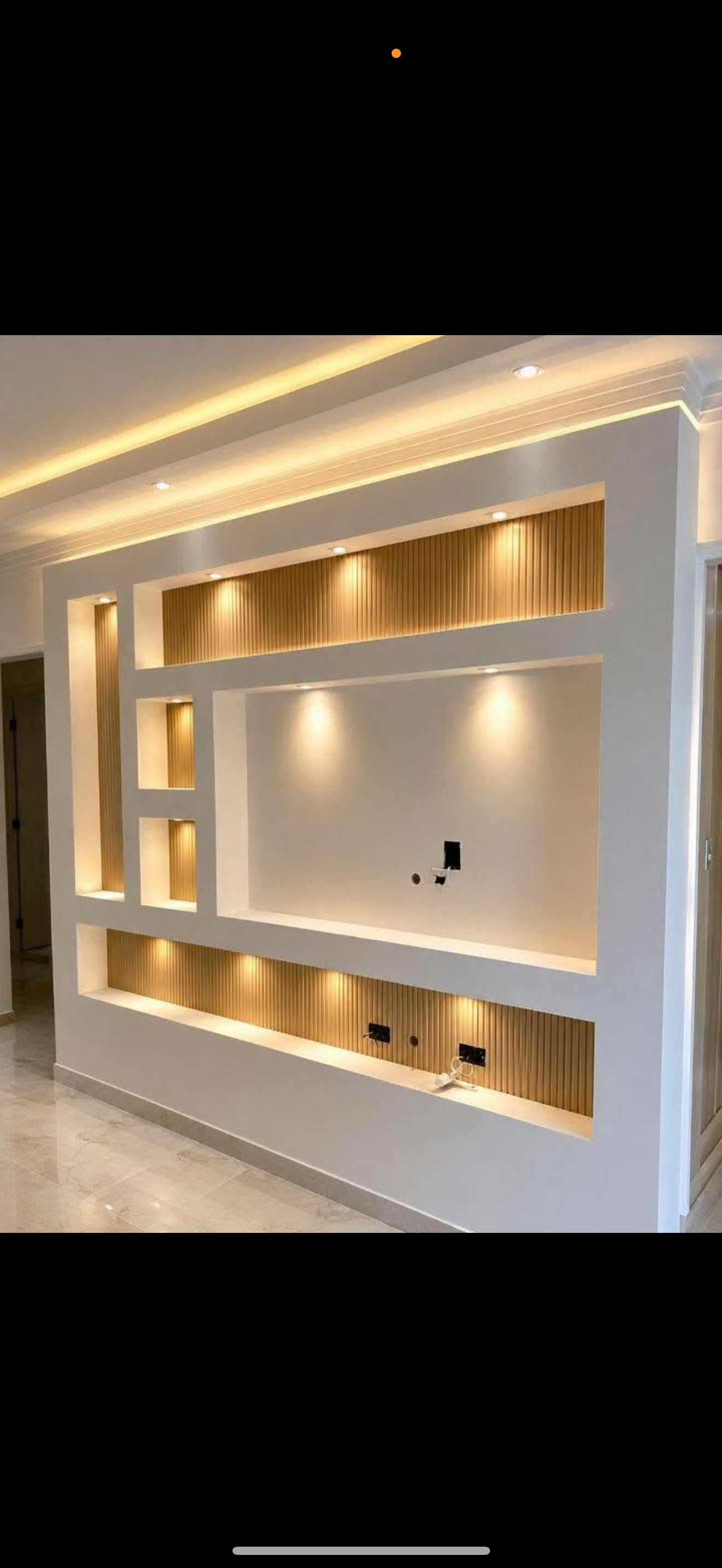 White drywall TV feature wall with fluted wood-lined recessed niches, backlighting and a floating shelf