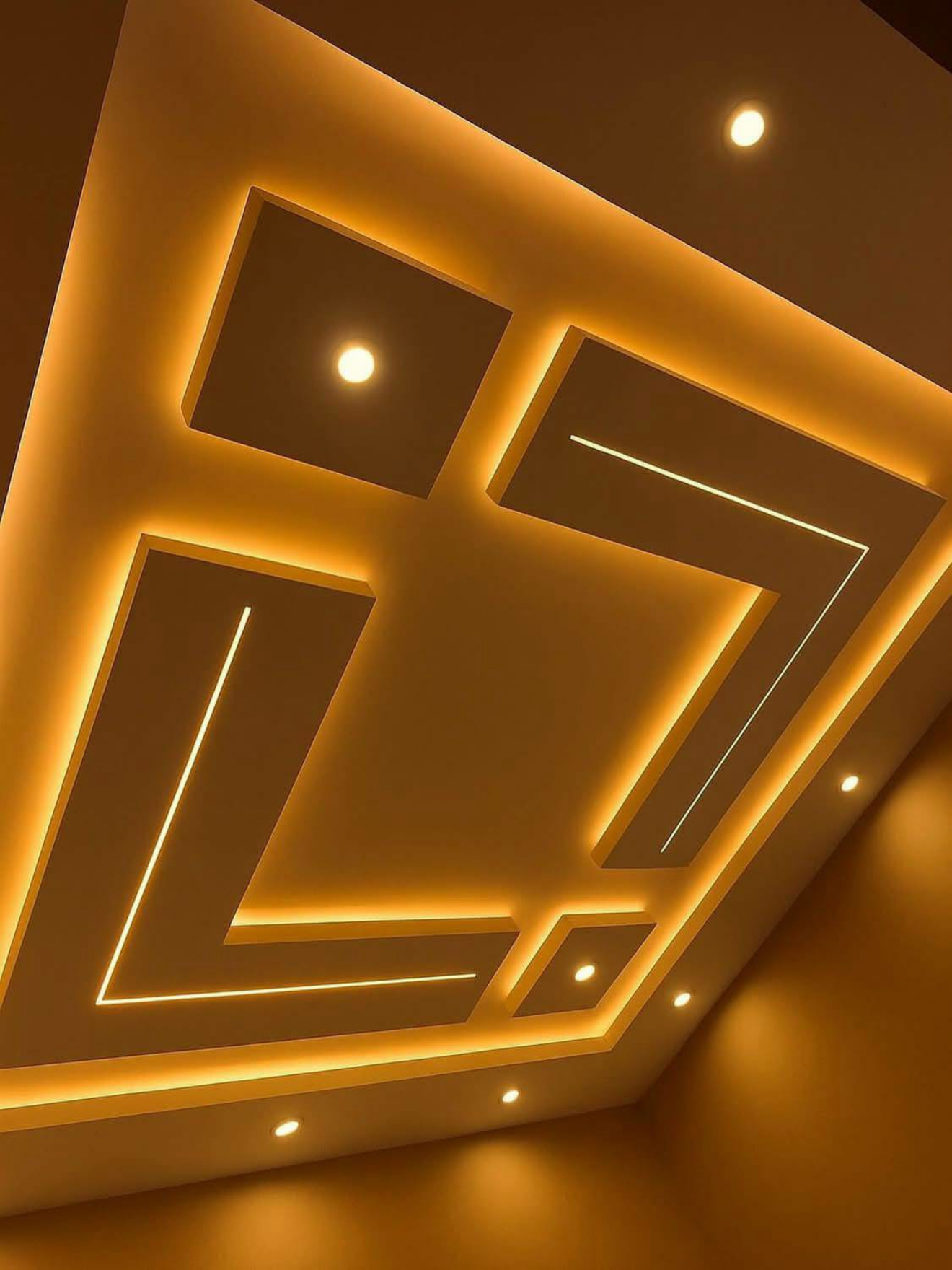 Geometric drywall ceiling design with warm LED strip lighting and recessed spotlights