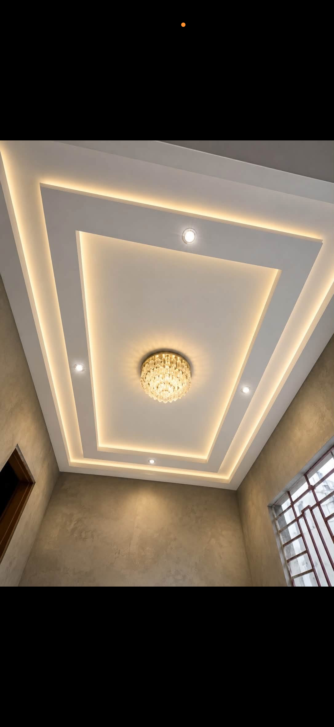 Stepped rectangular drywall tray ceiling with warm LED cove lighting and a crystal flush-mount chandelier